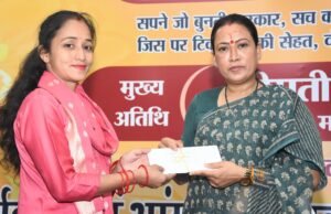 कैबिनेट मंत्री रेखा आर्य से नियुक्ति पत्र प्राप्त करती नवनियुक्त आंगनबाड़ी कार्यकर्ता।